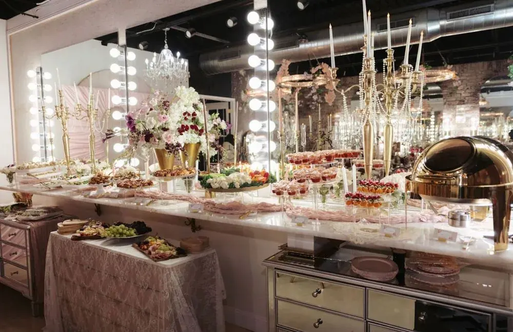 A pink-and-gold dessert grazing table styled with florals